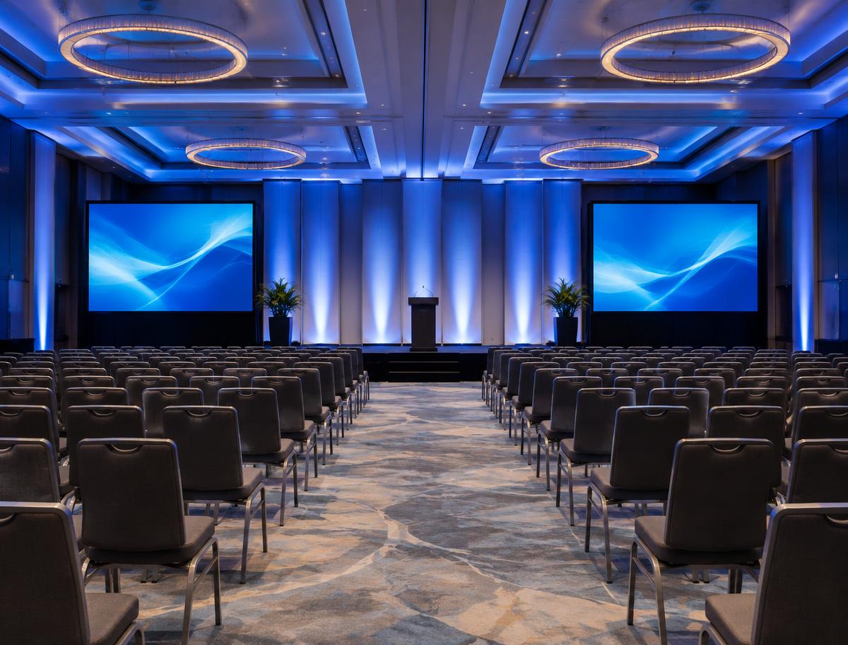 Conference hall with side LED screens and blue uplighting